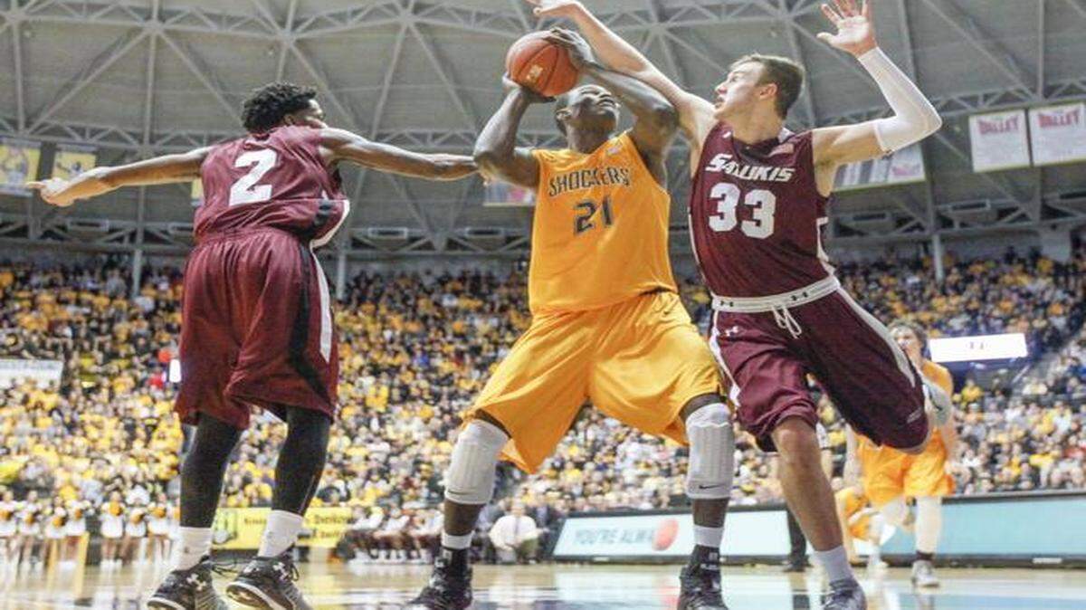 
Wichita State's Bush Wamukota powers up a shot despite the defense of Southern Illinois' K.C Goodwin (2) and Sean O'Brien in the second half Wednesday at Koch Arena.
