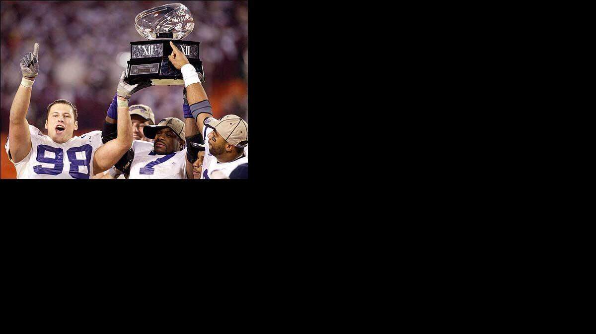 
Kansas State players hold up the Big 12 championship trophy after the Wildcats’ shocking 35-7 win over Oklahoma at Arrowhead Stadium in 2003.
