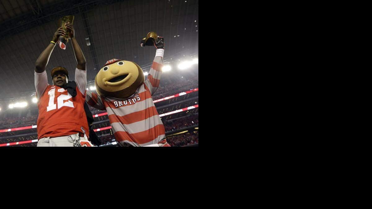
Ohio State's Cardale Jones and the Buckeyes’ mascot celebrate after the OSU’s 42-20 win over Oregon on Monday night in the College Football Playoff national championship game.
