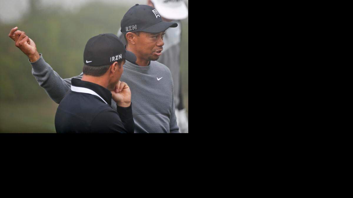 
Tiger Woods mimics a swing move to coach Chris Como while on the range prior to playing in the pro-am event at the Farmer Insurance Open golf tournament on Feb. 4.

