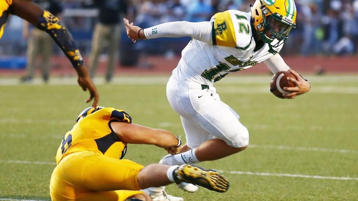 Bishop Carroll quarterback Braden Howell eludes Northwest’s Garrett Bridwell in the second quarter Thursday night. Bishop Carroll won 40-35.