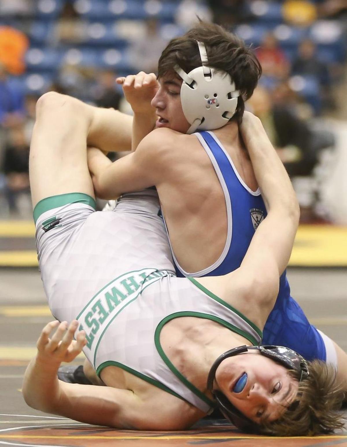 Kapaun's Michael Spangler puts a move on Brandon Madden of Blue Valley Southwest during their Class 5A 120-ppound final on Saturday at Hartman Arena. Spangler won his third state title.