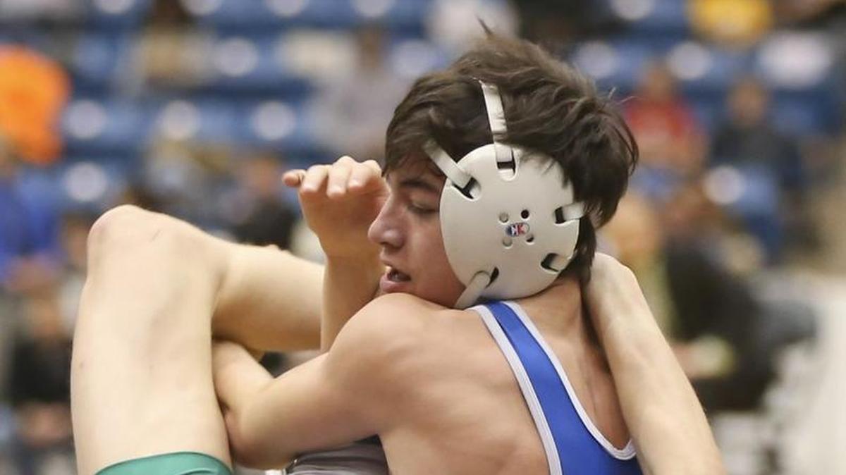 Kapaun's Michael Spangler puts a move on Brandon Madden of Blue Valley Southwest during their Class 5A 120-ppound final on Saturday at Hartman Arena. Spangler won his third state title.
