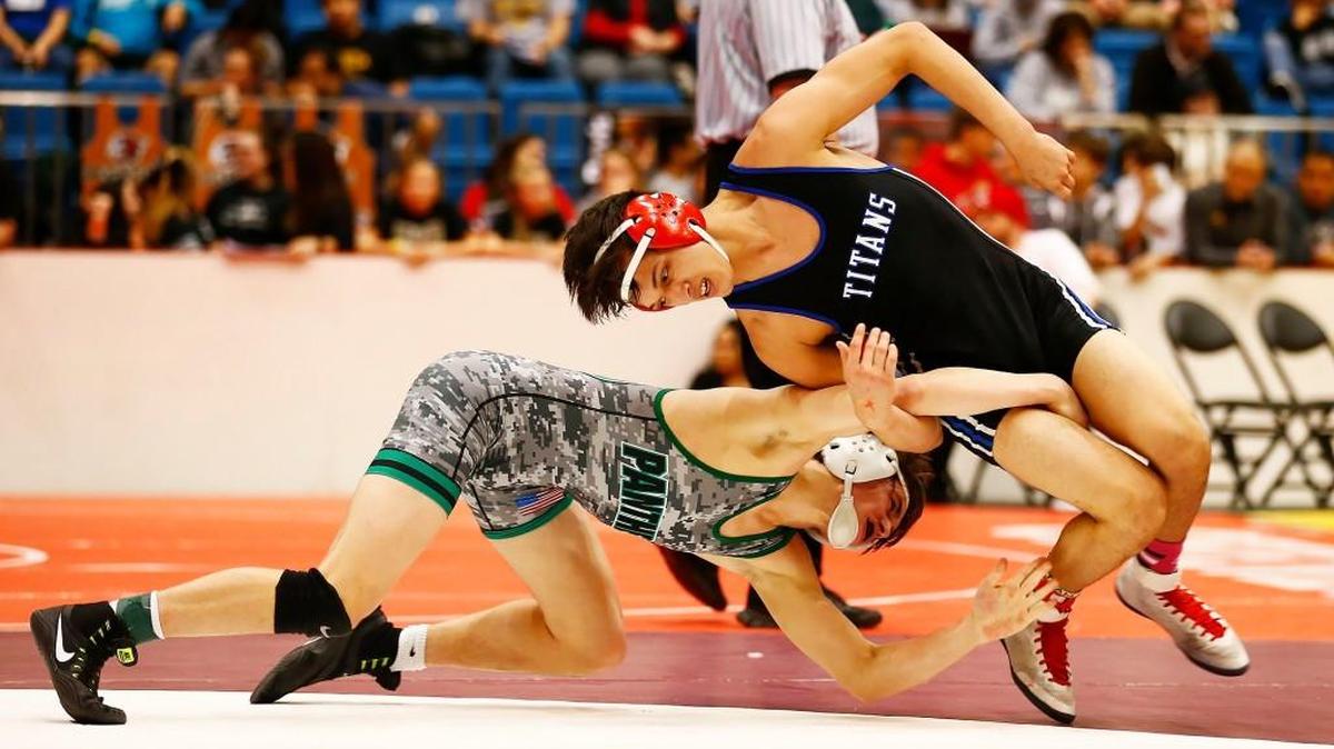 Derby’s Cade Lindsey, left, tries to grab the legs of Wichita South’s Asiel Flores during their match in the 138-pound semifinals at the Class 6A tournament in February. Lindsey begins this season at the top-ranked wrestler at 152.