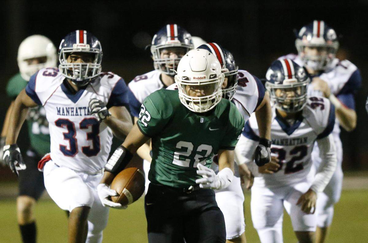 Derby running back Tre Washington heads for the end zone as Manhattan defenders give chase on in the opening moments of Friday’s Class 6A football semifinal at Derby. (November 16, 2018)