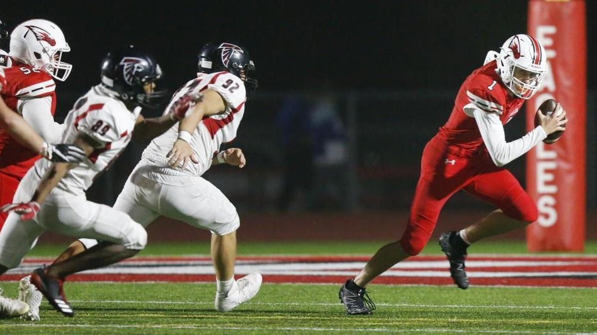 Maize’s Caleb Grill scrambles from Heights defenders in the second quarter Friday at Maize.